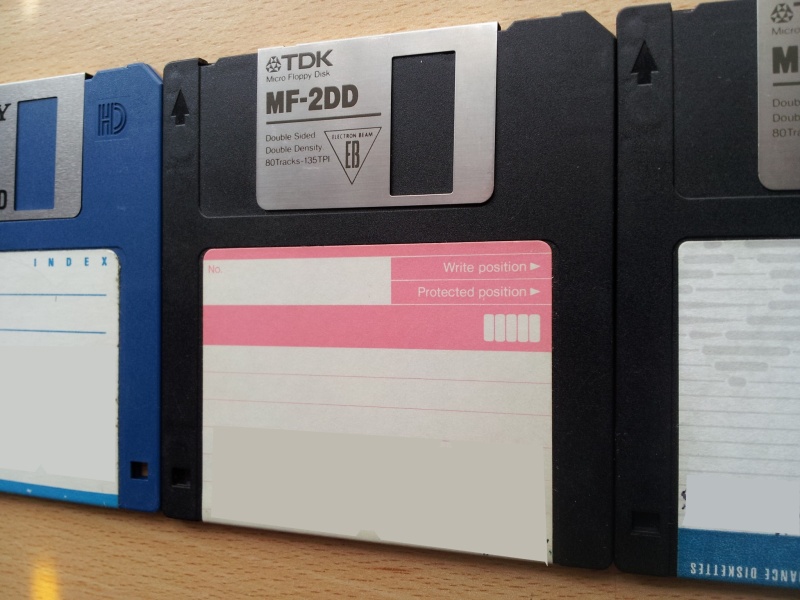 A row of 3 off floppy disks 3.5 inches awaiting Word file extraction. The disks are photographed at an angle with only part shown of disks 1 and 3. 